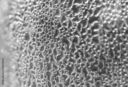 .Drops on the wall of the bottle, condensation of water on the bottle. Bottle took out of the fridge and formed a sweat. Blurred background.