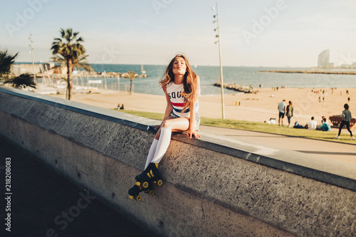 Young vintage brunette girl posing and smiling in a sunset on the streets of Barcelona