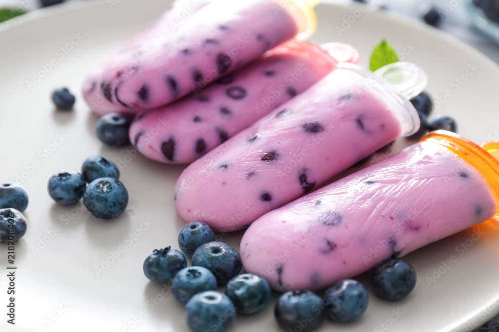 Tasty blueberry popsicles with berries on plate, closeup Tasty blueberry popsicles with berries on plate, closeup