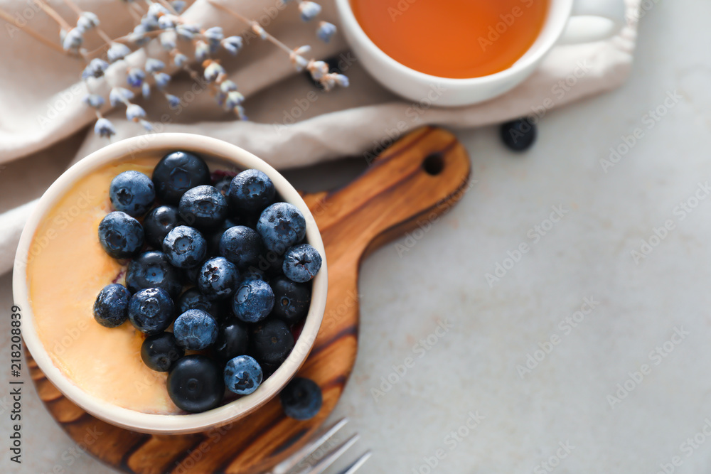Bowl with delicious blueberry pudding on light table Bowl with delicious blueberry pudding on light table