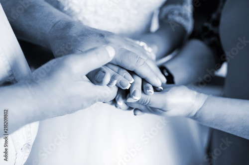 Closeup of a stack of hands. People, putting their hands on each other, symbolize unity, love and teamwork.