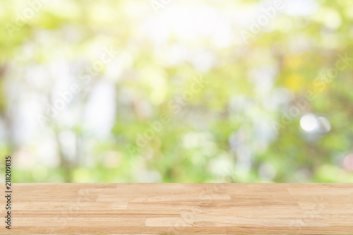 Empty wooden desk of free space and spring time with blurred background of home garden for a catering or food background Template mock up for display montages of product.