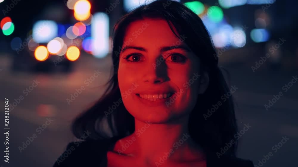 Portrait of beautiful brunette woman smiling and looking at camera. Night city street background bokeh. Portrait of beautiful brunette woman smiling and looking at camera. Night city street background bokeh.