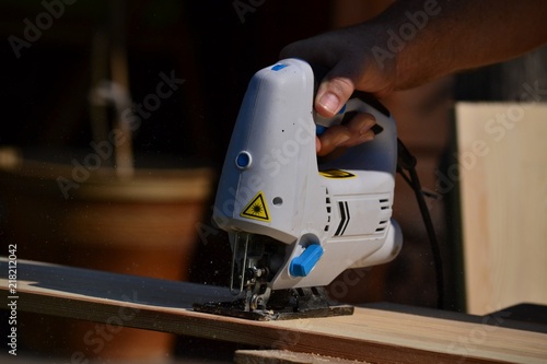 Cutting the boards with a jigsaw - the chips are flying (close-up)