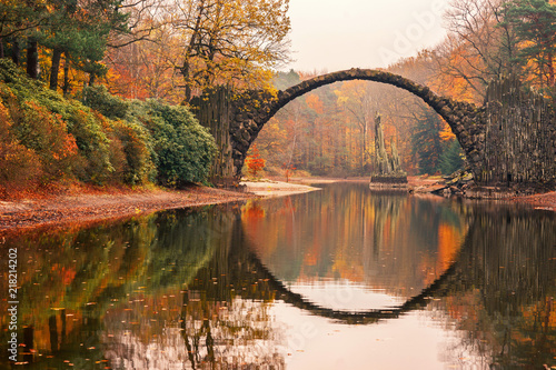 Rakotz Bridge (Rakotzbrucke, Devil's Bridge) in Kromlau, Saxony, Germany. Colorful autumn, reflection of the bridge in the water create a full circle.Unusual and interesting places in Germany.
