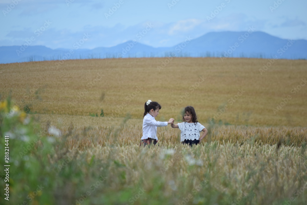 Two girls playing in the wheat field