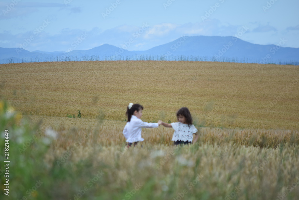 Two girls playing in the wheat field Two girls playing in the wheat field