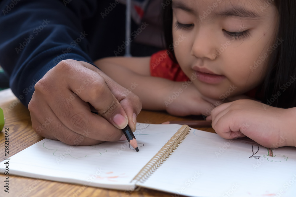 Happy family. Adult man helping the child girl drawing. Dad and child daughter together draws are engaged in creativity in kindergarten. Happy family. Adult man helping the child girl drawing. Dad and child daughter together draws are engaged in creativity in kindergarten.