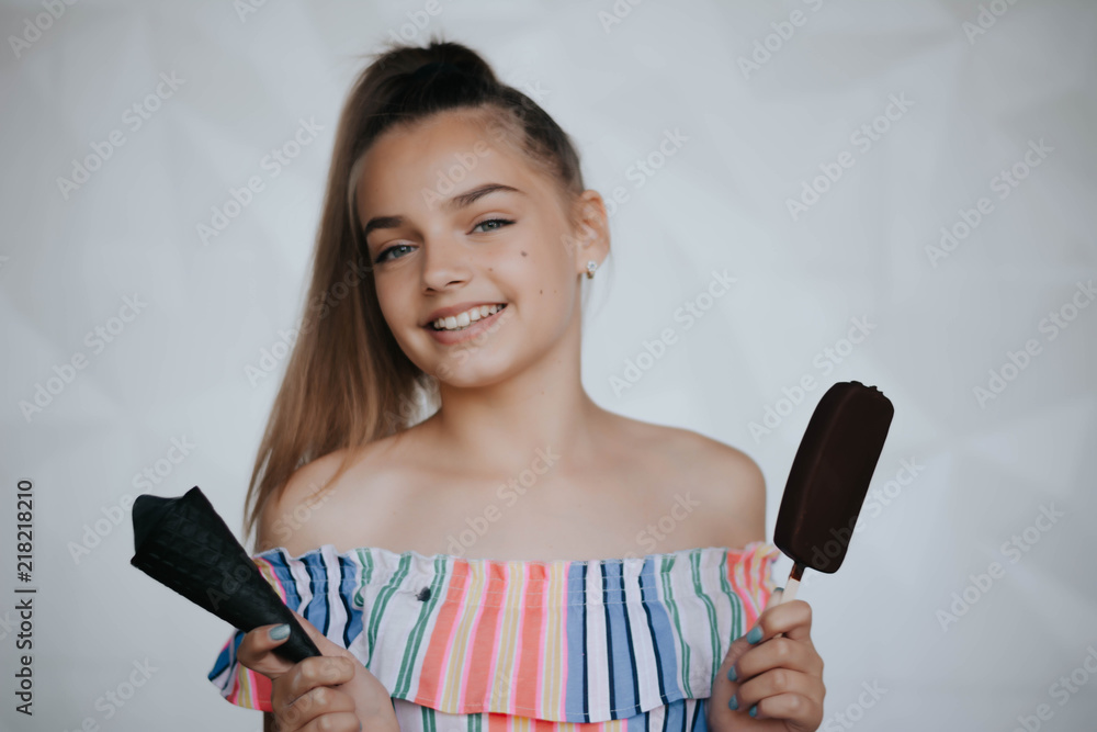 Happy girl eating ice cream. Young hipster girl eating a delicious ice cream in summer hot weathe. Chocolate. Cream. Ice. Sweet Tooth Happy girl eating ice cream. Young hipster girl eating a delicious ice cream in summer hot weathe. Chocolate. Cream. Ice. Sweet Tooth