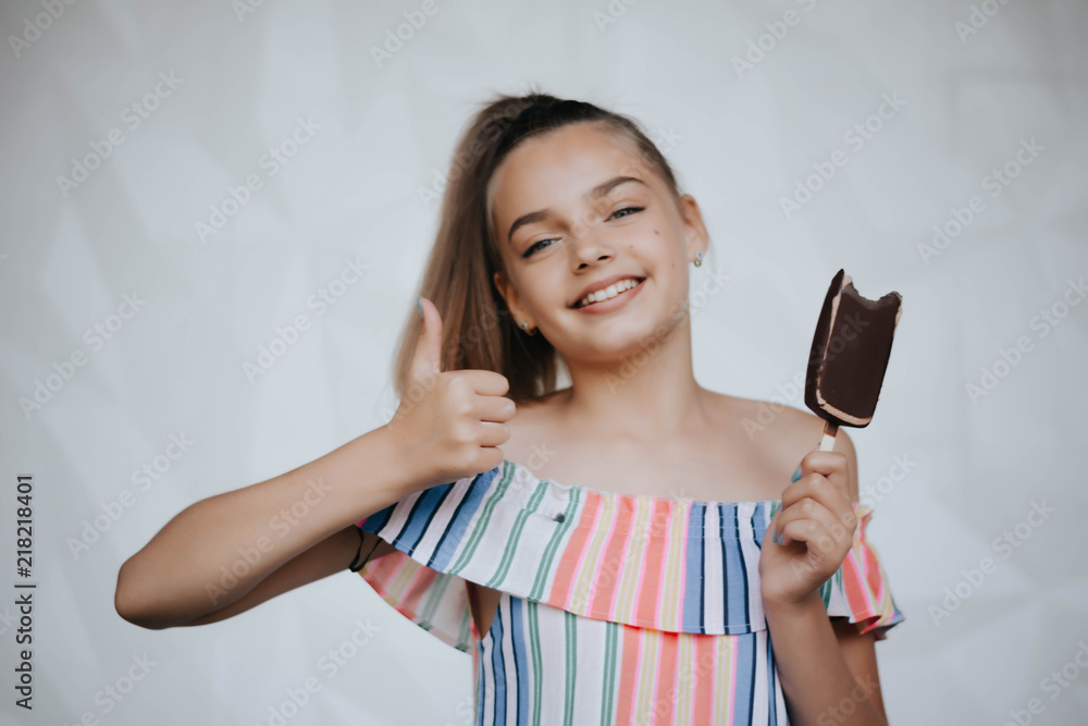 Happy girl eating ice cream. Young hipster girl eating a delicious ice cream in summer hot weathe. Chocolate. Cream. Ice. Sweet Tooth Happy girl eating ice cream. Young hipster girl eating a delicious ice cream in summer hot weathe. Chocolate. Cream. Ice. Sweet Tooth