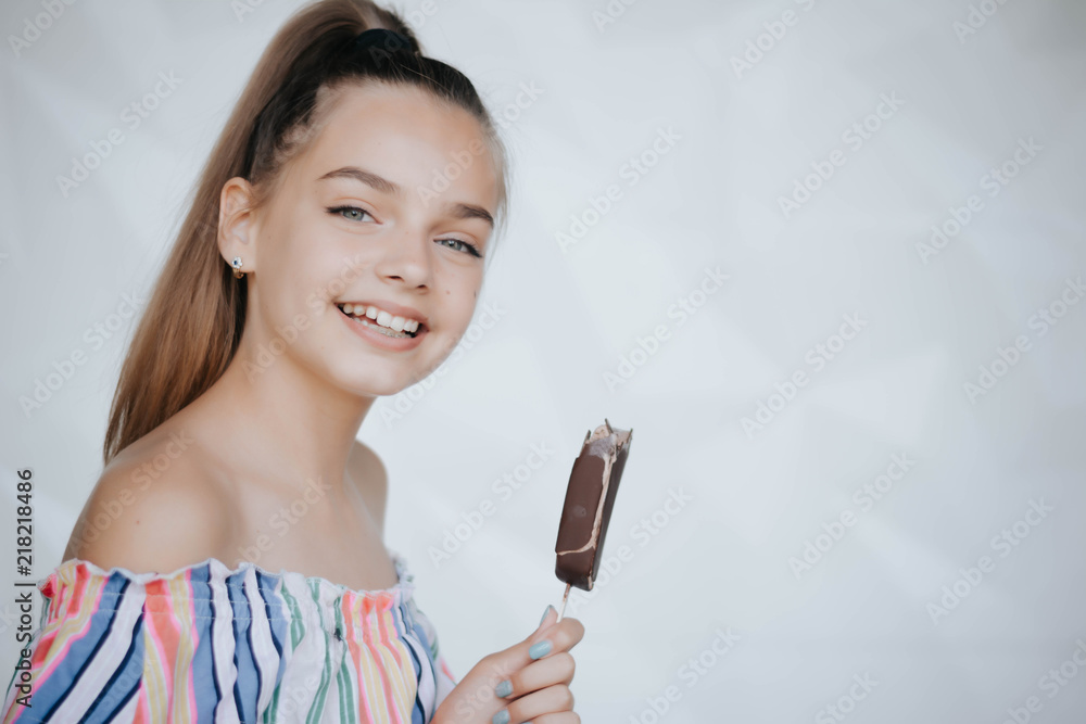 Happy girl eating ice cream. Young hipster girl eating a delicious ice cream in summer hot weathe. Chocolate. Cream. Ice. Sweet Tooth Happy girl eating ice cream. Young hipster girl eating a delicious ice cream in summer hot weathe. Chocolate. Cream. Ice. Sweet Tooth
