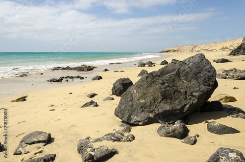 Big black volcanic rock on a tropical beach