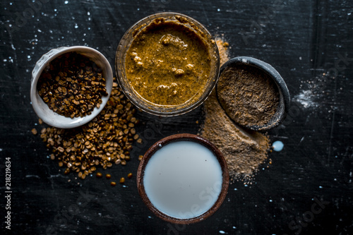 Close up of ayruevdic face pack of mung dal with sandal wood or chandan with milk and oats on wooden surface used to cure acne and pimples. photo