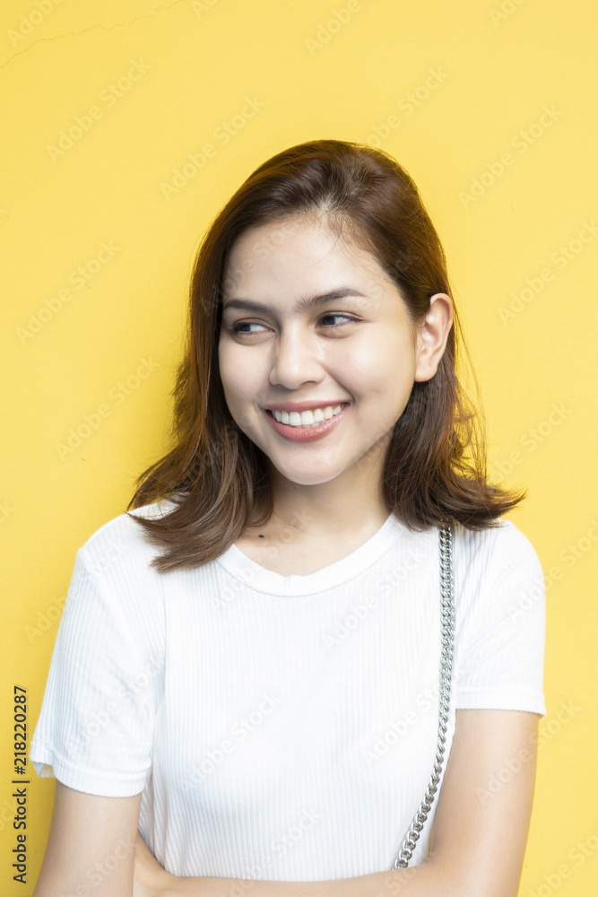 portrait of beautiful university student is smiling on yellow wall background portrait of beautiful university student is smiling on yellow wall background