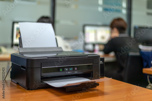 black printer in office with soft-focus and over light in the background photo