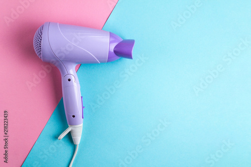 Hairdryer on a bright, colored background. Hairdressing Supplies. Beauty saloon. Fashion concept. Top view. Copy space