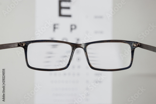 Close-up of eyeglasses for vision, pointing at table to check view. The concept of poor vision, blindness, vision testing, a trip to the ophthalmologist.