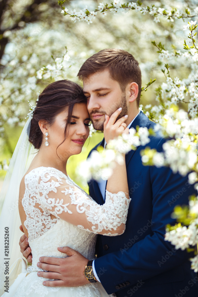 Obraz premium young and beautiful bride and groom enjoy each other. wedding couple enjoying romantic moments outside.