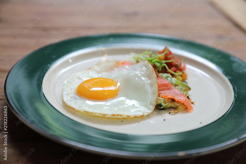 Zucchini fritters with egg and smoked salmon on wood background vinage style Zucchini fritters with egg and smoked salmon on wood background vinage style
