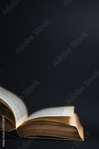 Altes ge  ffnetes Buch auf schwarzem Hintergrund