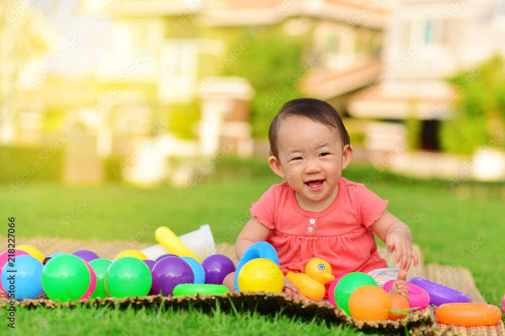 Obraz premium Cute Asian baby playing with toys and smile in playground 