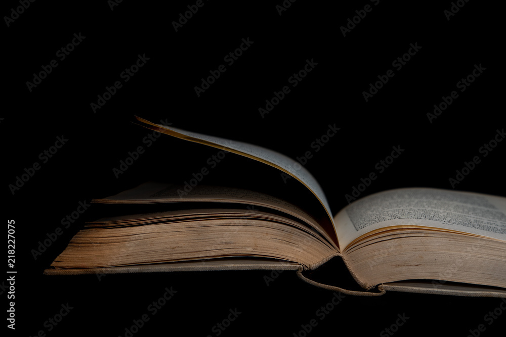 Verblichenes Buch auf schwarzem Hintergrund liegend Verblichenes Buch auf schwarzem Hintergrund liegend