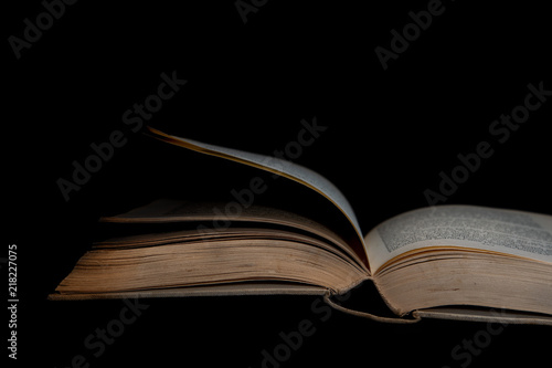 Verblichenes Buch auf schwarzem Hintergrund liegend