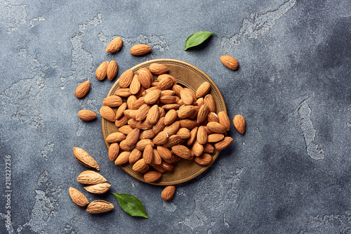 Almond nuts on gray concrete background with copy space. Top view.