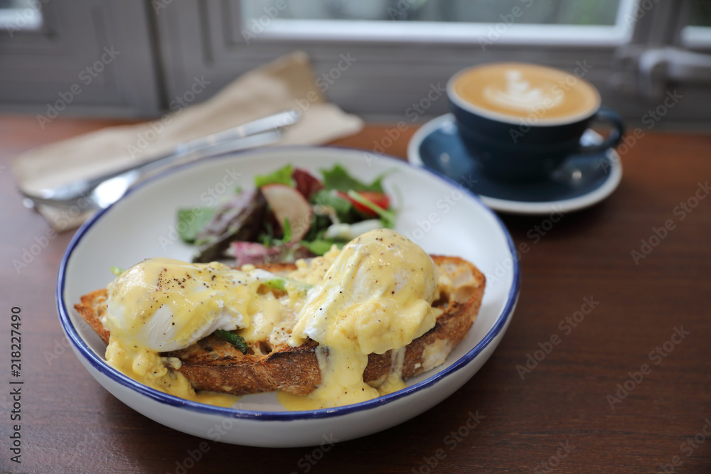 Egg benedict , poached eggs with toast and cappuccino on wood background , English Breakfast Egg benedict , poached eggs with toast and cappuccino on wood background , English Breakfast