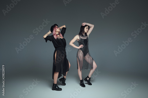 Fototapeta Naklejka Na Ścianę i Meble -  Two fashionable girls wearing black trendy outfits posing