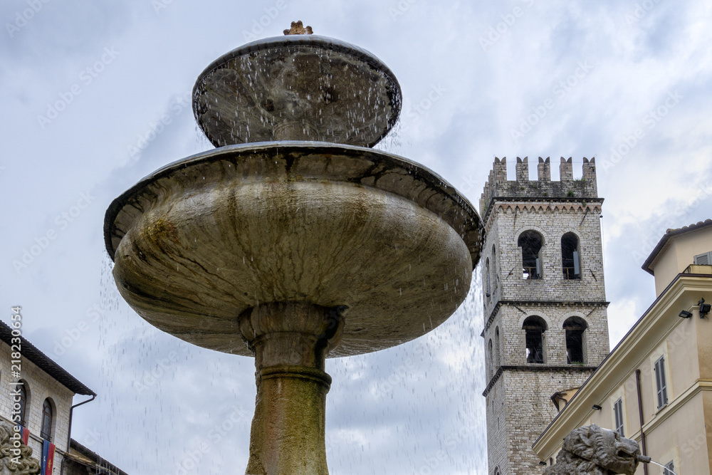 Brunnenschalen der FONTANA DEI TRE LEONI auf dem Marktplatz (Piazza del Comune) von Assisi. Im Hintergrund der  Torre del Popolo des Palazzo del Capitano