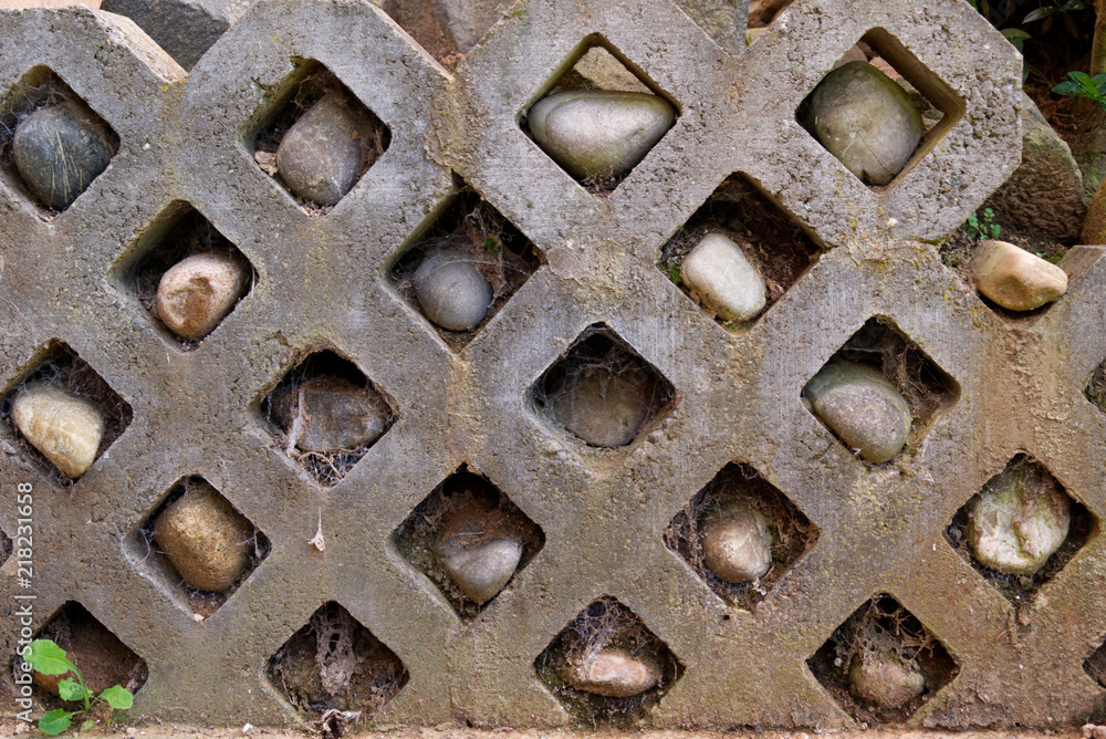 Stone wall with rocks in holes and spiderwebs - Garden Stone wall with rocks in holes and spiderwebs - Garden