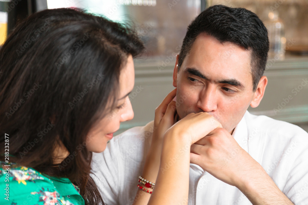 Naklejka premium Man looks in eyes of his wife and kisses her hand