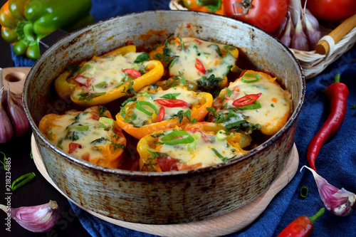 Stuffed halves of bell peppers with mince and cheese in a frying pan. European and Caucasian cuisine meal