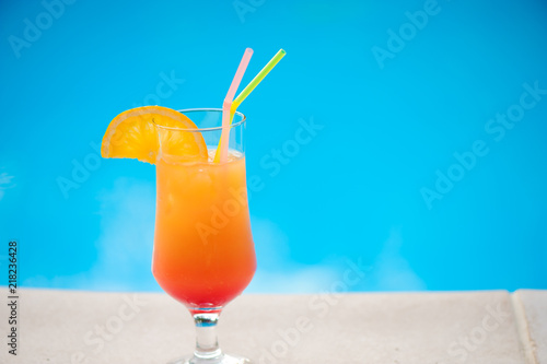 Cocktail next to swimming pool, summer vacation concept