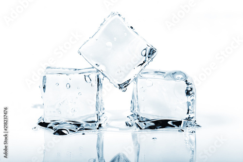 Three ice cubes melting isolated on white.