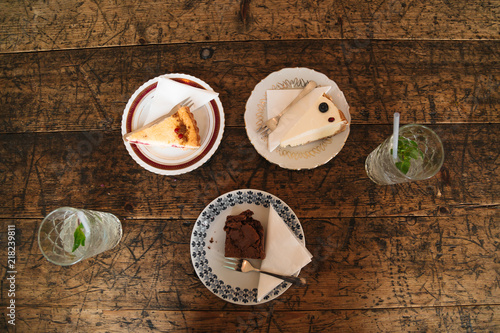 Cheesecakes and chocolate cake on vintage plates photo