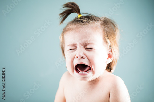 Unhappy baby girl crying and whining photo