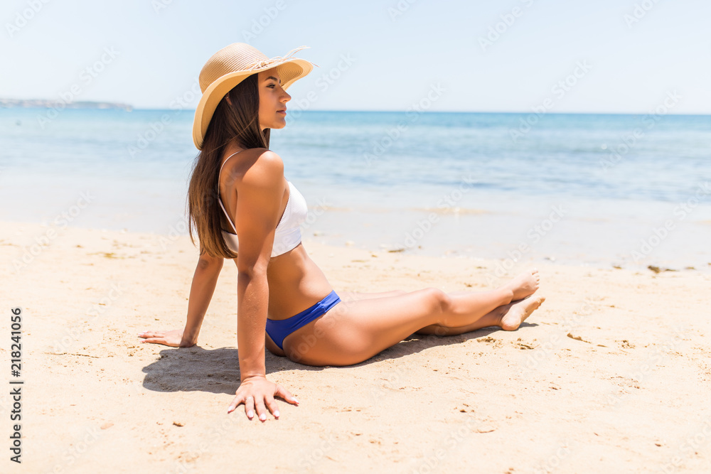 Young latin woman in straw hat lying on the sand the ocean coast
