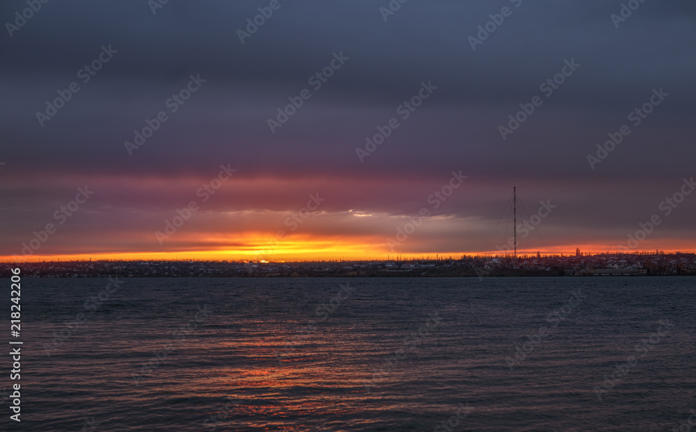 Sunset over the river and dark clouds
