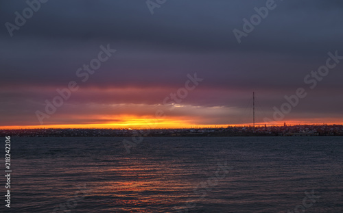 Sunset over the river and dark clouds © AlexGo
