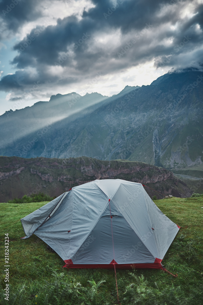 tent standing in front mountain view at the morning with god rays
