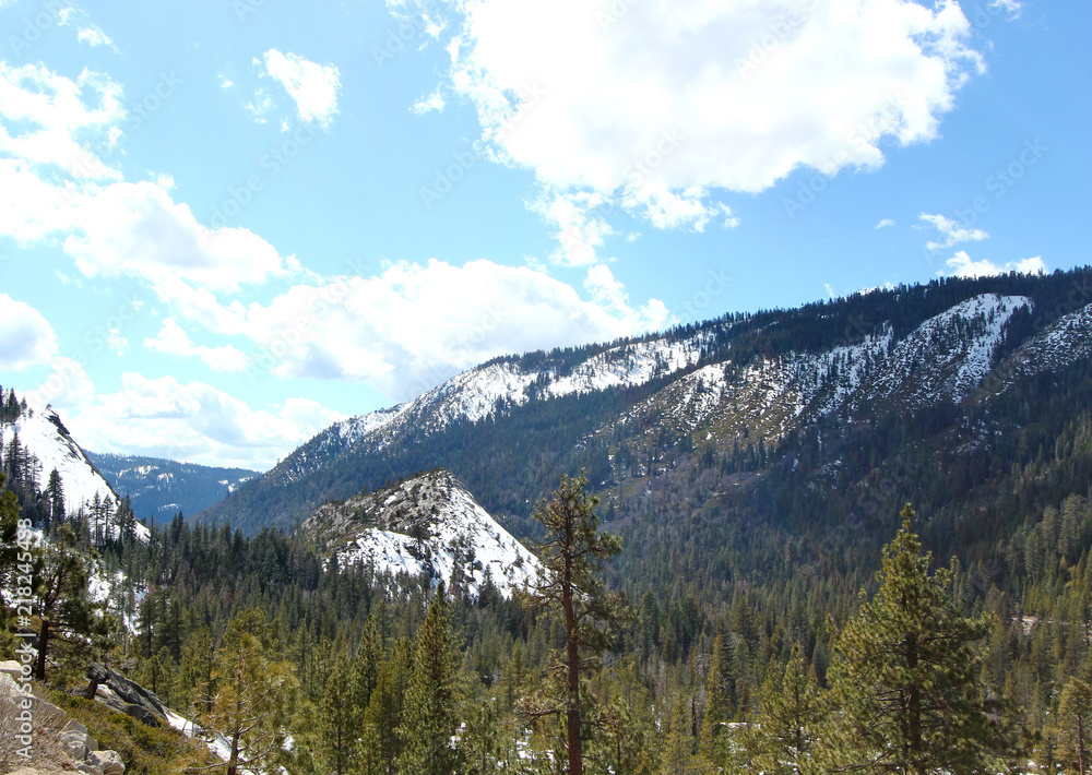 Obraz premium A road to lake Tahoe with snow capped mountains.