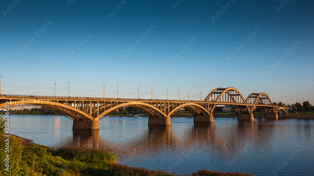 Volga bridge over Volga river at sunset time with reflection in water. Beautiful evening landscape