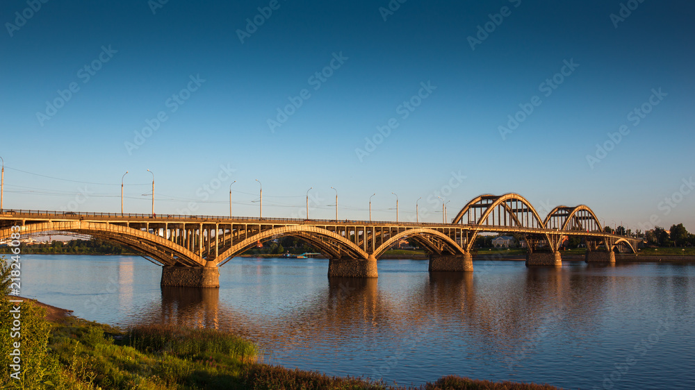 Volga bridge over Volga river at sunset time with reflection in water. Beautiful evening landscape Volga bridge over Volga river at sunset time with reflection in water. Beautiful evening landscape