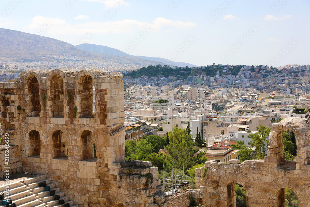 Ruins of ancient theater on the Acropolis with cityscape of Athenas. The Odeon of Herodes Atticus on the south slope of the Acropolis in Athens, Greece. 