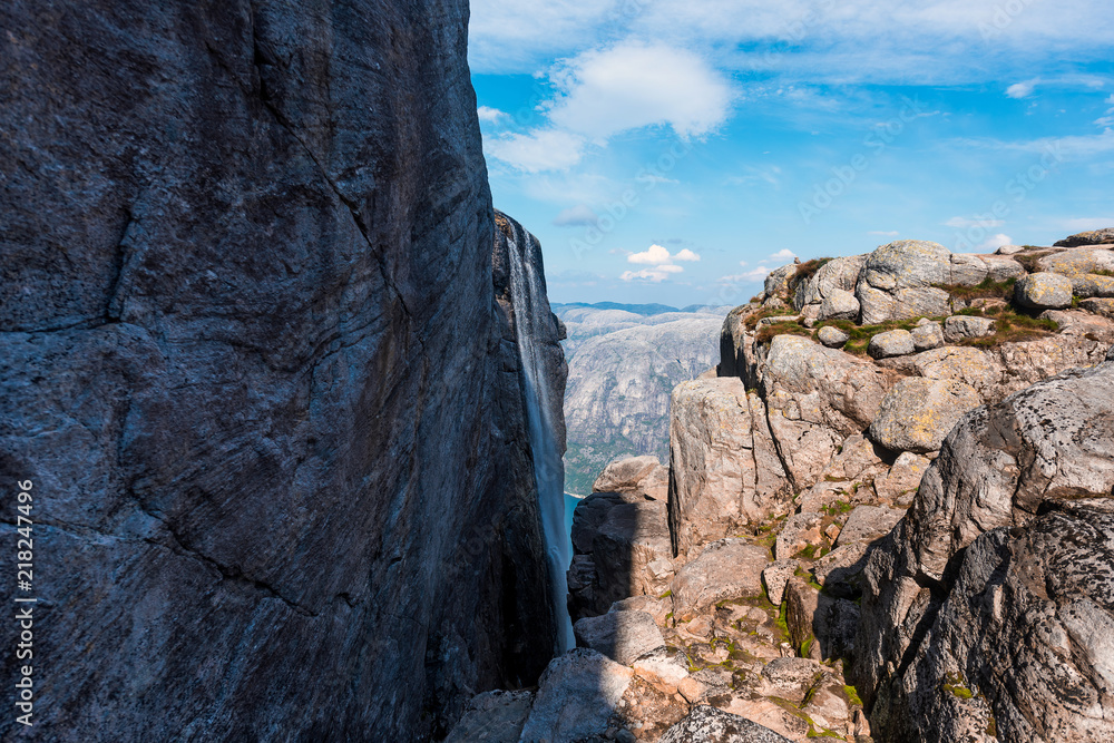 Portrait of a extreme plan travel for the handsome old man on the stone of the kjerag in the mountains kjeragbolten of Norway,   selfie on a smartphone holding in your freedom hand