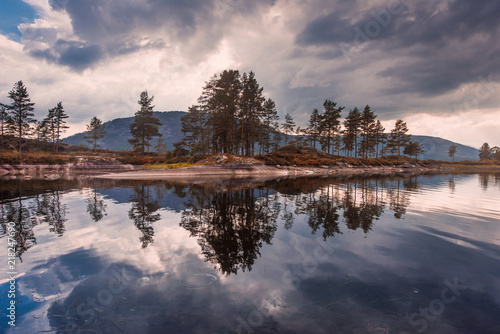 Landscape travel on the way to  the stone of the kjerag in the mountains kjeragbolten of Norway, reflection of trees in the lake on the Sunset © bublik_polina