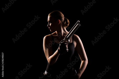 Military woman with a gun over black background
