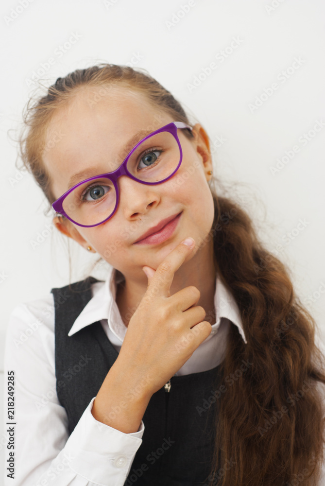 Portrait of a cute school girl in academic clothes, Wearing white shirt and grey dress. Girl with purple eye glasses. Educational concept. Isolated. Back to school. Portrait of a cute school girl in academic clothes, Wearing white shirt and grey dress. Girl with purple eye glasses. Educational concept. Isolated. Back to school.